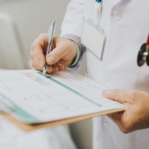 Physician noting down symptoms of a patient