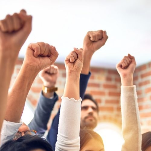 Group of business workers standing with fists up at the office