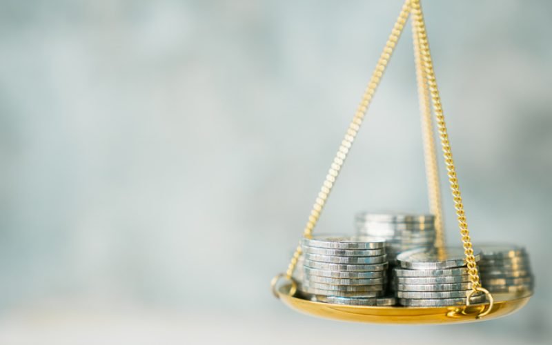 Coins stack with balance scale. Money management, financial plan, time value of money, business idea and Creative ideas for saving money concept.