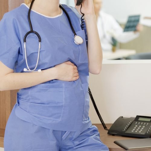 pregnant nurse is working in the office