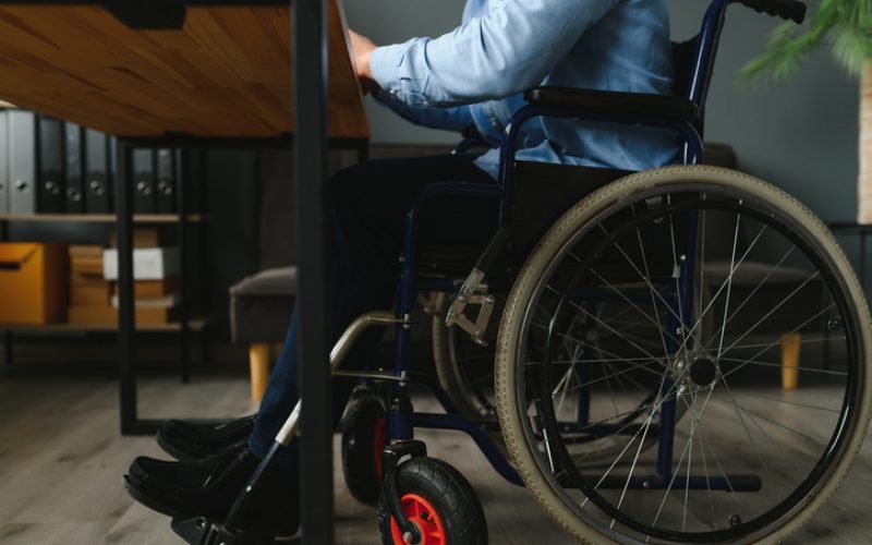 Man in wheelchair at home or in office.