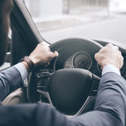 Young business person test drive new vehicle steering wheel