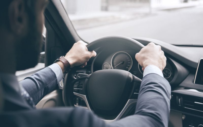 Young business person test drive new vehicle steering wheel