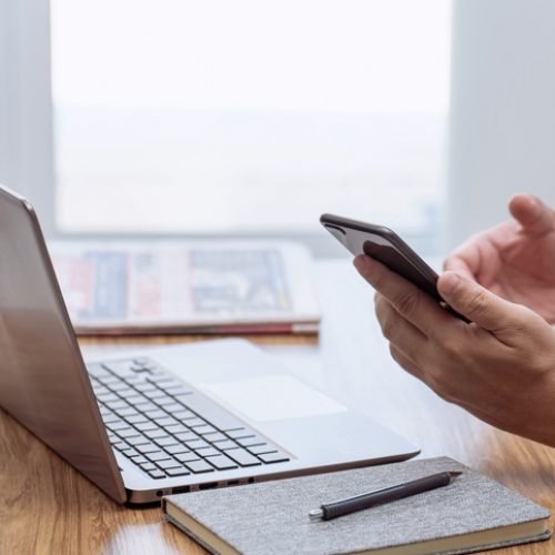 Businessman in the workplace. Texting message smartphone and use the laptop computer and office blur background