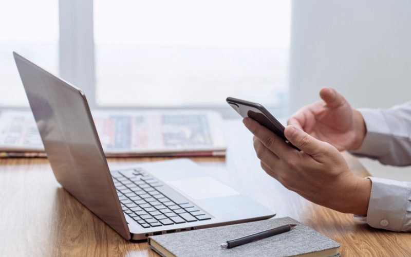 Businessman in the workplace. Texting message smartphone and use the laptop computer and office blur background