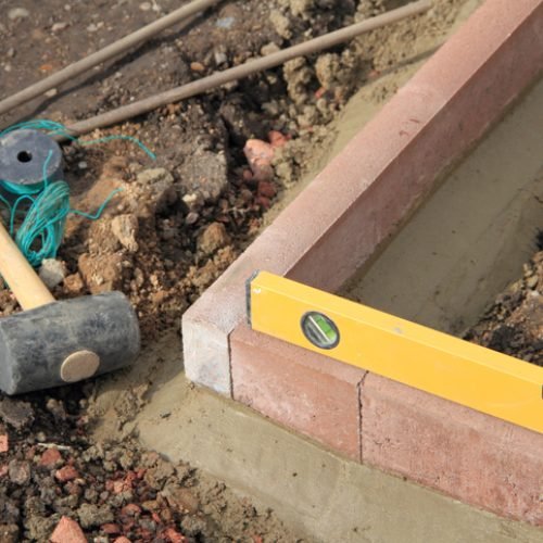 setting new edging stones in the garden with tools