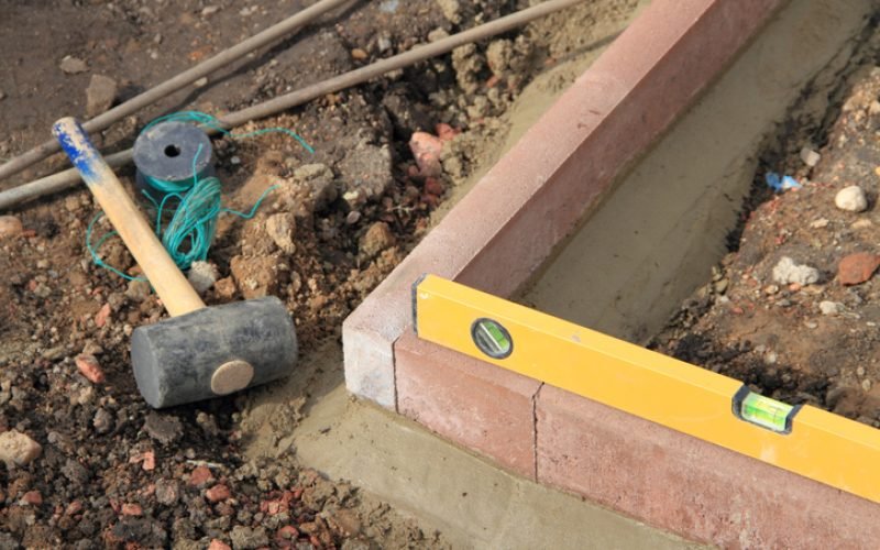 setting new edging stones in the garden with tools