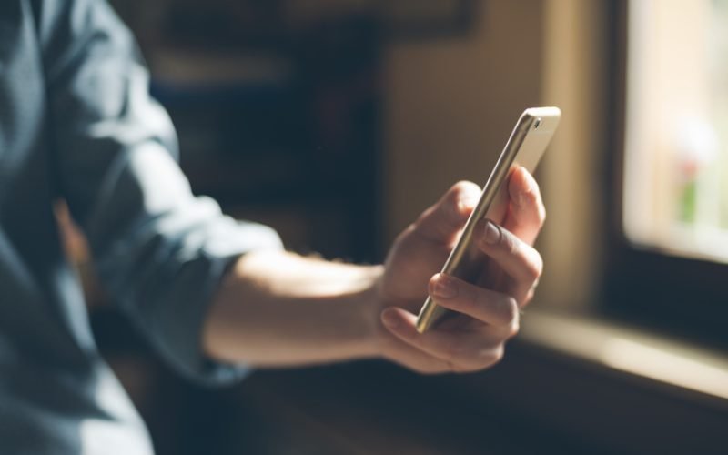 Hipster using a touch screen smart phone hands close up, vintage colors